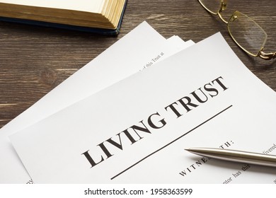 Living trust papers with pen and book.