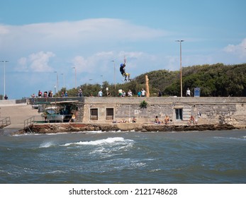 Livorno, Italy - August 2021: High Jump Of A Kitesurf In Slow Motion During A Windy Day.