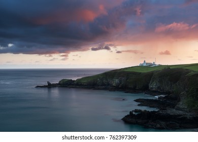 Lizard Point Lighthouse in Cornwall under a fiery sunset