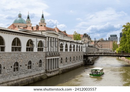 The Ljubljana Dragon Bridge spans the Ljubljanica River, Ljubljana Central Market and Saint Nicholas's Cathedral (Katedrala Sv. Nikolaj), dragon sculpture, Slovenia.