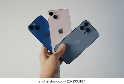 Ljubljana, Slovenia - 2021 November 8: Male hand compare Apple iPhone 13, 13 Pro and 13 Mini