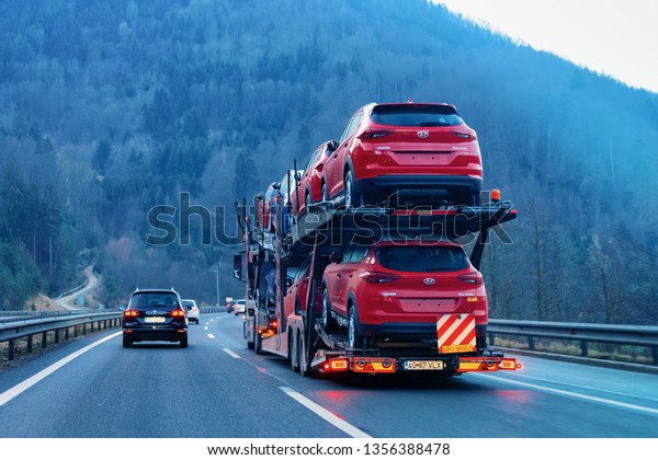 Ljubljana, Slovenia - January 14, 2019: Red Car\
carriers transporter truck on road. Auto vehicles hauler on\
driveway. European transport logistics at haulage work\
transportation. Heavy haul\
trailer
