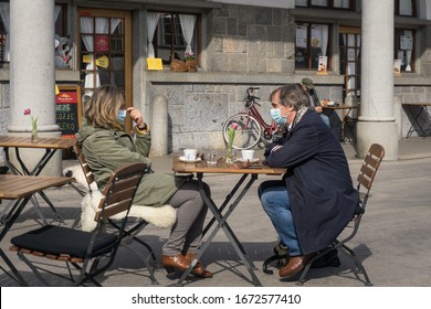 Ljubljana / Slovenia - March 14, 2020: A Couple Wears Masks To Help Prevent Against Covid-19 Corona Virus As They Eat Outside In Ljubljana, Slovenia.   