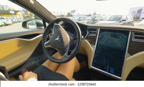 LJUBLJANA, SLOVENIA, MARCH 2018 - CLOSE UP: Unknown Businesswoman Presses A Button On The Touchscreen Display And The Autonomous Parks Itself In Reverse Into Vacant Parking Spot. Self Parking Vehicle.