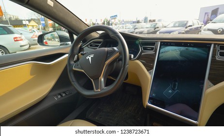 LJUBLJANA, SLOVENIA, MARCH 2018 - CLOSE UP: Self Steering Car Backs Up Into The Vacant Parking Spot Without A Human Driver Inside The Cockpit. Tesla Vehicle Navigating Around The Crowded Parking Lot.