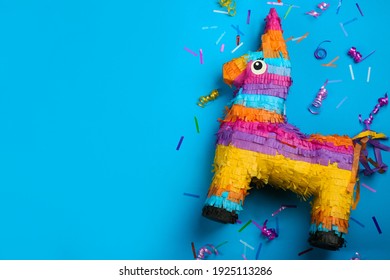 Llama shaped pinata, streamers and glitter on light blue background, flat lay. Space for text