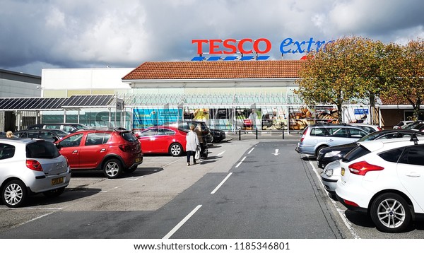 Llanelli, UK: September 21, 2018: Customers enter\
a Tesco Extra superstore. Tesco is a British multinational grocery\
and general merchandise retailer. It is the third-largest retailer\
in the world.