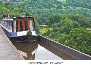 LLANGOLLEN, WALES - JUNE 17 2014: A boat crosses the Pontcysyllte Aqueduct that carries the Llangollen Canal over the River Dee valley, Wales. Canal trips are a popular tourist attraction in the area.