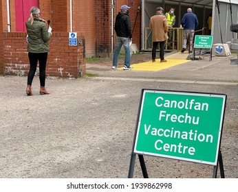 Llantrisant, Wales - March 2021: People Queuing At A Covid Vaccination Centre Set Up In A Local Leisure Centre.