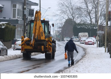 Llantwit Fardre, Pontypridd, Wales, UK - March 03 2018: Storm Emma Thaws Out, A Man Walks His Dog Home From The Shops Along Slushy Roads, While A Tractor Drives Past. 