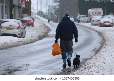 Llantwit Fardre, Pontypridd, Wales, UK - March 03 2018: Storm Emma Thaws Out, A Man Walks His Dog Home From The Shops Along Slushy Roads. 