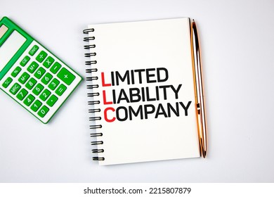 The LLC - Limited Liability Company Text On Notepad Next To Calculator And Pen.