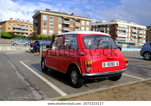 Lloret de Mar, Catalonia, Spain - 11.11.2021:\
bright red Mini 850 model old retro car in perfect condition parked\
on the city street