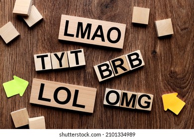 LMAO, TYT Take your time, BRB Be Right Back, Be Right Back, LOL, Lots of Laughs, OMG, Oh my God, text message abbreviation on wooden cubes in the shape of a crossword puzzle. Internet slang.