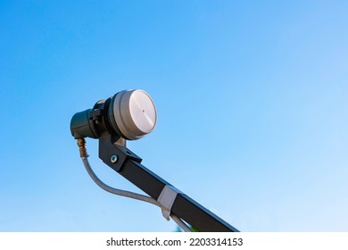 LNB On The Feedhorn Isolated On Blue Sky Background. Satallite Communication Background Photo.