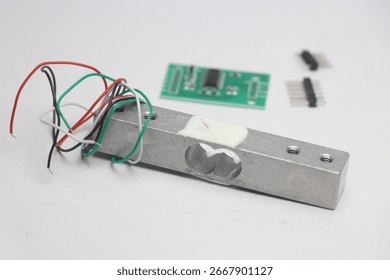 Load cell module with amplifier on the background with unsoldered pins on a white background