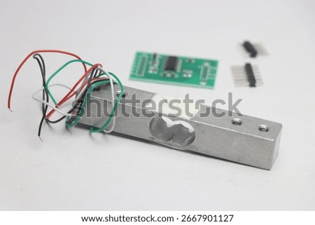 Load cell module with amplifier on the background with unsoldered pins on a white background