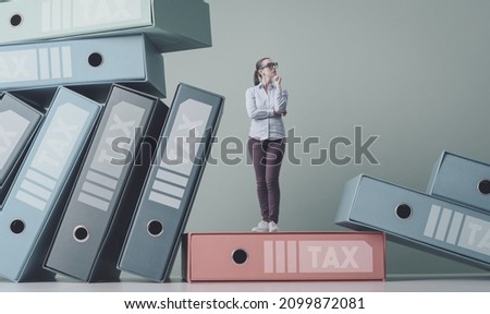 Load of ring binders with tax documents and pensive businesswoman, tax services and solutions concept