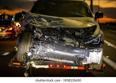 Loaded Broken Wrecked Car On A Tow Truck After Crash At Night