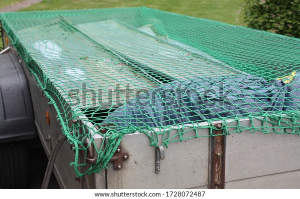 Loaded car trailer\
with load securing net