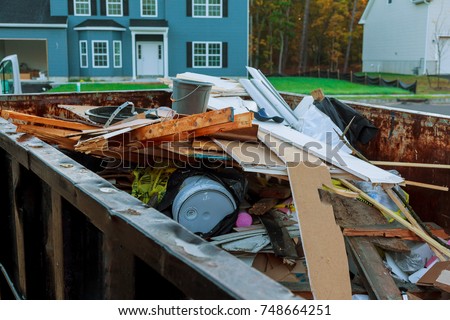 Loaded dumpster near a construction site, home renovation dumpster filled with building rubble dumpster