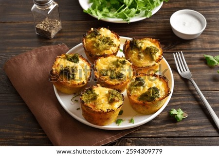 Loaded egg muffins made with eggs, ham, broccoli, cheese on brown wooden table. Tasty meal for breakfast or lunch. Close up view
