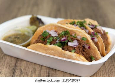 Loaded Slow Cooked Birria Meat Tacos Topped With Onions And Served With A Grilled Jalapeno, Salsa, And Guacamole.