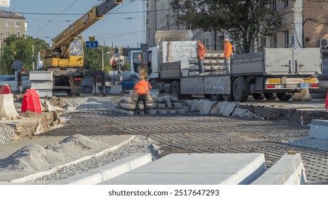 Loader crane for loading and unloading sleepers to reinforcement from oversized truck with an extended loading platform which stands on a road construction site aerial timelapse