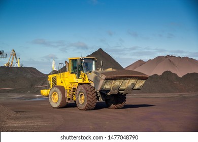 Вucket loader rides through an open coal warehouse with cargo in a bucket
bucket loader ore coal warehouse stack cargo machinery mechanism loading port commercial trade cranes
