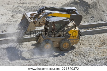 loader small bulldozer moving breakstone at construction area. view from above.