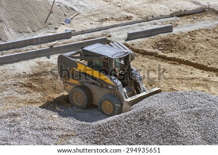 loader small bulldozer moving breakstone at construction area. view from above.