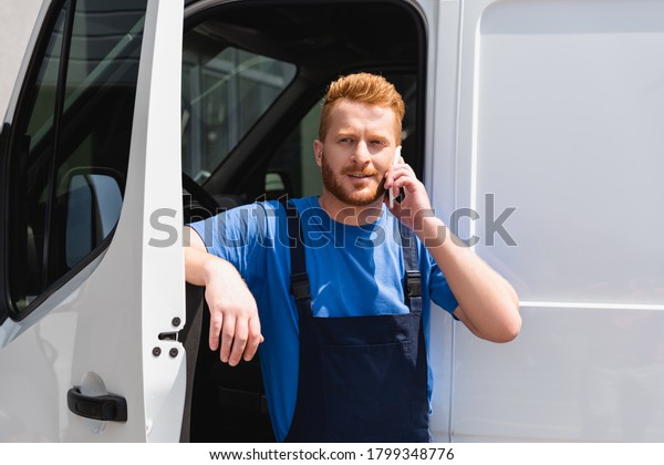 Loader talking\
on smartphone near truck\
outdoors