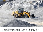 Loader working at outdoor gravel and sand warehouse