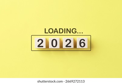 Loading 2026 New Year Progress Concept. Wooden cubes number 2026 inside progress bar with word loading on bright yellow background, symbolizing preparation, progress, goal setting, and upcoming goals.