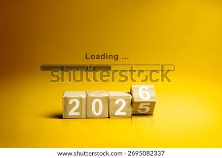 Loading bar with wooden cubes transform from the number 2025 to 2026 on a yellow background. Happy New Year concept or Celebration