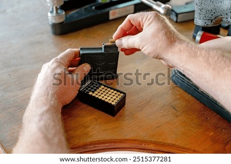 Loading bullets rounds cartridges ammunition into rifle magazine, sports shooting shooter, gun club association, weapon lobby