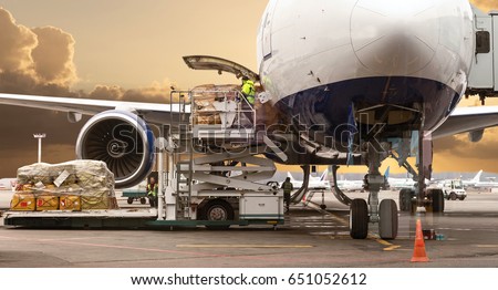Loading cargo on the plane in airport, view through window