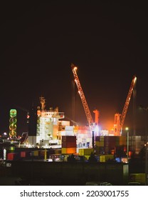 Loading Cargo Ship In Batumi Sea Port Late At Night Work In Darkness. Import Export Caucasus Business Industrial Zone