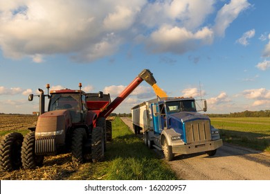 Loading Crop Of Corn To Semi Truck From Combine Harvester After Harvest