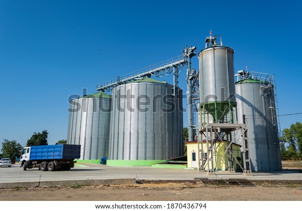 loading grain by trucks onto the elevator into\
metal containers