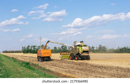 Loading grain from a combine into a truck. Harvesting grain in Ukraine. - Shutterstock ID 2179366985