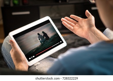 Loading Icon Rolling On Video In An Online Movie Streaming Service. Bad And Slow Internet Connection. Film Player Stopped. Frustrated And Confused Man Watching And Holding Tablet While Spreading Arms.