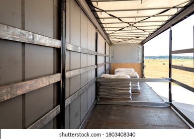 Loading Into A Tilt Trailer Of A Truck. The Process Of Unloading Goods From A Large Truck