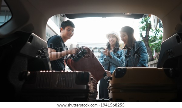 Loading luggage into a car by tourist prepare to go\
to travel road trip by car. Friend group loading baggage in to car\
trunk ready for road\
trip.