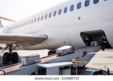 Loading luggage on the plane. The baggage on the conveyor belt to the airplane. - Shutterstock ID 2143889733