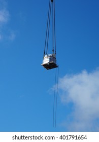 Loading a palette tied with chains while hanging in the sky