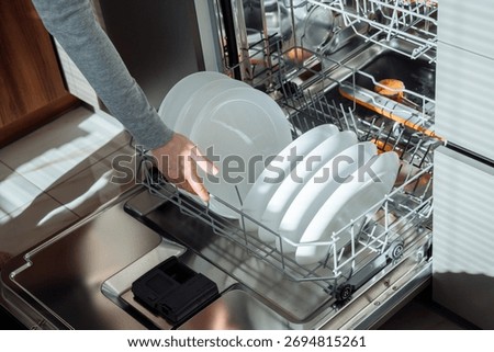 Loading plates into dishwasher rack - dishwasher, plates, loading, kitchen, clean.