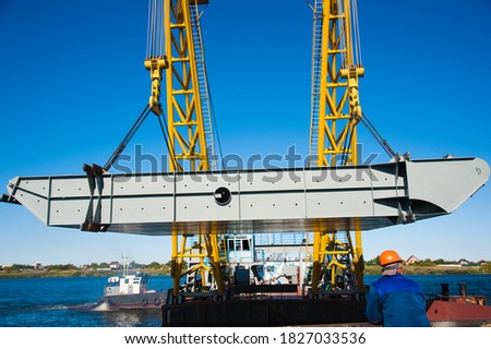 Loading in port. Floating port crane on blue sky background. Chains and hooks hoist with slings for loading in the port close-up