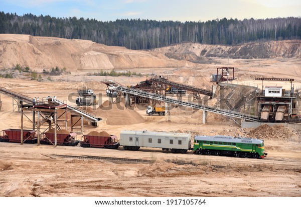 Loading sand into freight cars of a train in\
quarry. Sand Making Plant in open-pit mining. Crushing factory,\
machines and equipment for crushing, grinding stone, sorting sand\
and bulk materials