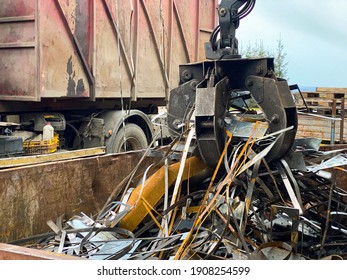 Loading scrap metal into a truck Crane grabber loading metal rusty scrap in the dock A grapple truck loads scrap industrial metal for recycling - Shutterstock ID 1908254599